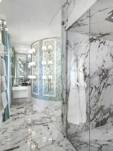 Geräumiges Badezimmer mit Marmorwänden und moderner Dusche