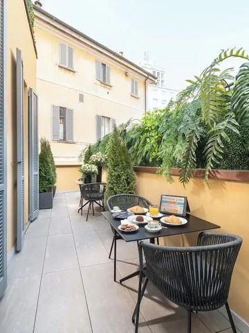 Terrasse mit Frühstückstisch und grüner Umgebung