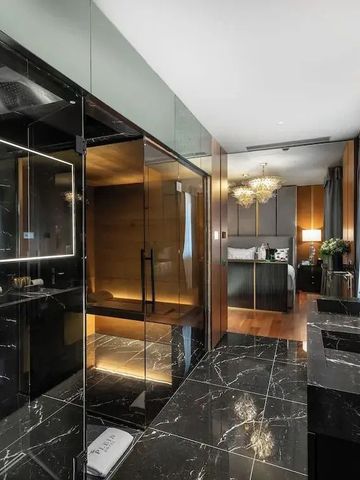 Luxuriöses Badezimmer mit edlen schwarzen Marmordetails und großer Dusche