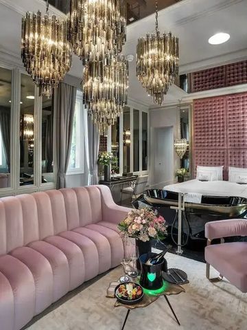 Luxuriöses Hotelzimmer mit rosafarbenem Sofa und edlen Kronleuchtern