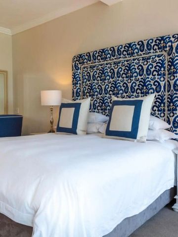 Elegantes Hotelzimmer mit Kingsize-Bett und blauer Akzentdecke