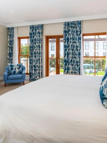 Geräumiges Zimmer mit großem Fenster und blauem Sessel