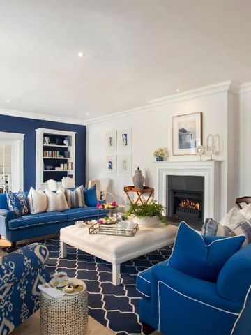 Elegante Lounge mit blauen Sofas und Kamin in einem luxuriösen Hotel.