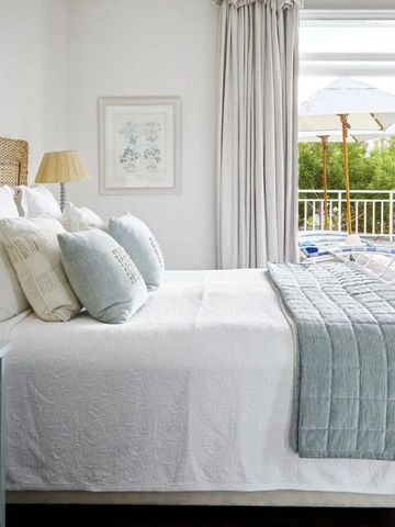 Helles Schlafzimmer mit Zugang zu einer Terrasse und Blick auf den Pool.