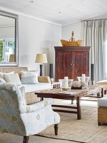 Geräumiges Wohnzimmer mit bequemen Sitzgelegenheiten und großen Fenstern.