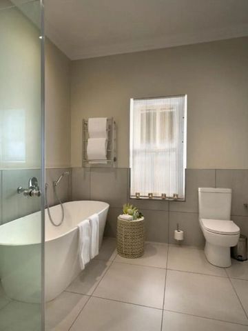 Modernes Badezimmer mit freistehender Badewanne und eleganter Einrichtung.