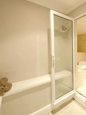 Wellnessbereich mit Sauna-Eingang und Handtüchern auf einer Bank.