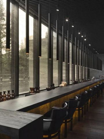 Eleganter Barbereich mit hohen Fenstern und modernem Design