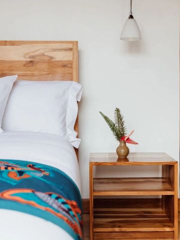 Stilvolles Hotelzimmer mit Holzbett und dekorativem Nachttisch