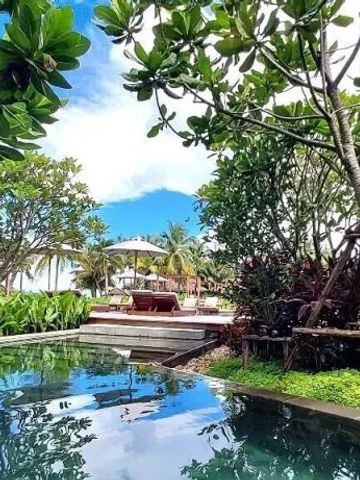 Tropische Gartenanlage am Hotel mit Pool und Liegen