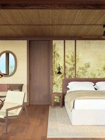 Warme Suite mit Holzdetails und einem Sofa vor einem großen Bett