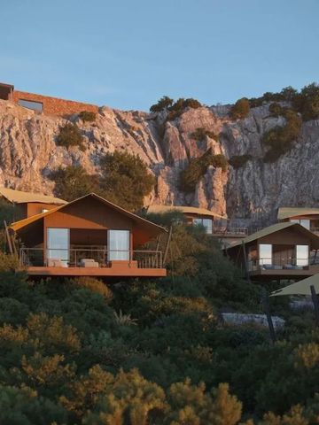 Premium-Bungalows vor einer malerischen Klippenlandschaft