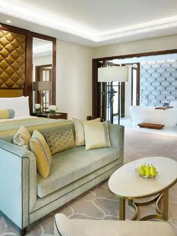 Großzügige Suite mit Sofa. Bett und freistehender Badewanne im Hintergrund