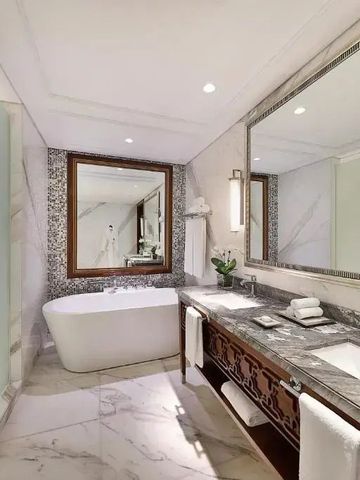 Luxuriöses Badezimmer mit Marmor-Details und freistehender Badewanne.