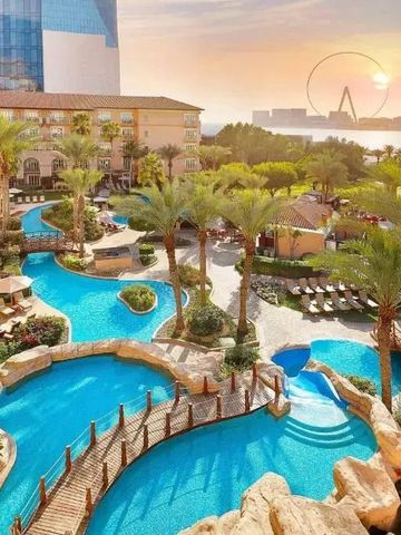 Weitläufiger Pool mit Palmen und Blick auf das Meer im Ritz-Carlton Dubai
