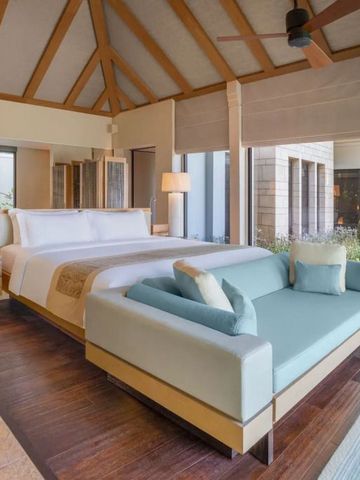 Geräumige Villa mit Holzbalken, großem Bett und Sofa im Resort-Stil