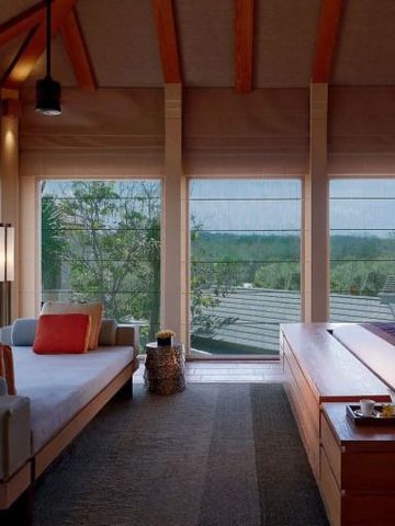 Zimmer mit Panoramafenstern und Blick auf die grüne Landschaft
