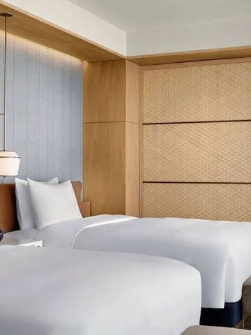 Modernes Hotelzimmer mit zwei Einzelbetten und eleganten Holzakzenten