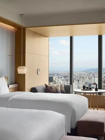 Hotelzimmer mit Panoramafenstern und weitem Ausblick auf die Stadt