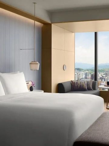 Helles Zimmer im Ritz-Carlton Fukuoka mit weitem Stadt- und Bergblick.