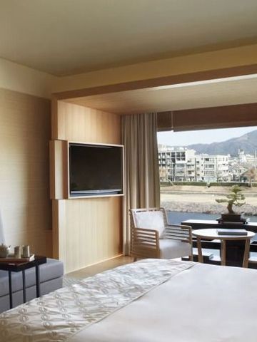 Hotelzimmer mit Panorama-Fenster und Blick auf die Stadt Kyoto.
