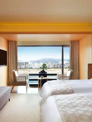 Helle Suite mit zwei Betten und großem Fenster mit Ausblick