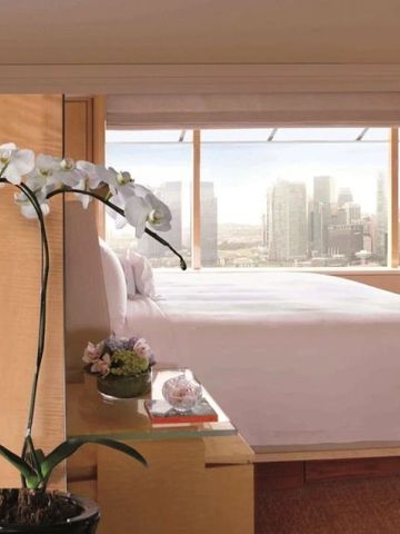 Elegantes Hotelzimmer mit Orchidee und Blick auf die Skyline von Singapur