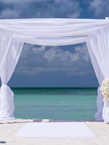 Weiße Hochzeitskapelle am Strand mit Blick auf das blaue Meer