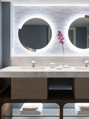 Stilvolles Badezimmer mit Doppelwaschbecken und Blumenakzent