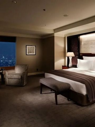 Elegantes Doppelzimmer bei Nacht mit Blick über die erleuchtete Stadt