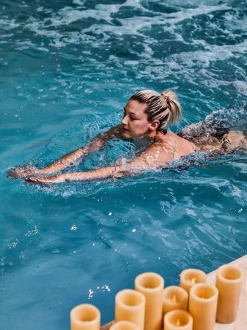 Frau schwimmt im Innenpool des Hotels