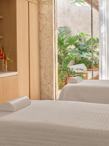 Eleganter Spa-Behandlungsraum mit Blick auf tropische Vegetation