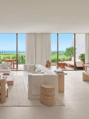 Geräumiges Wohnzimmer der Suite mit Blick auf Garten und Meer