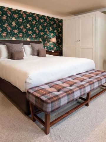 Elegantes Schlafzimmer mit floralem Tapetenmuster und Polsterbank