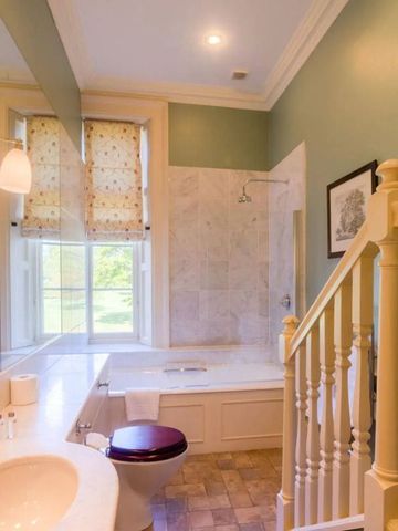 Helles Badezimmer mit Badewanne und grünen Wänden