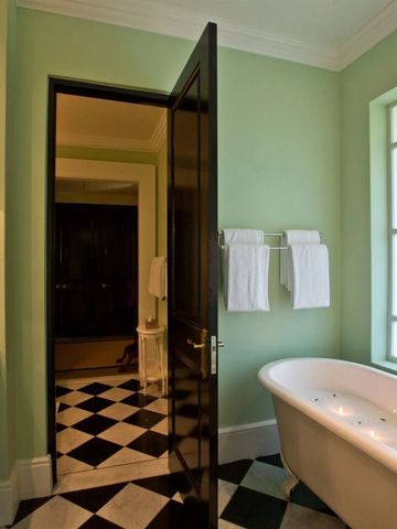Elegantes Badezimmer mit Badewanne und schwarz-weißem Fliesenboden