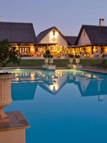 Abendstimmung am Pool mit Blick auf die beleuchtete Hotelarchitektur.