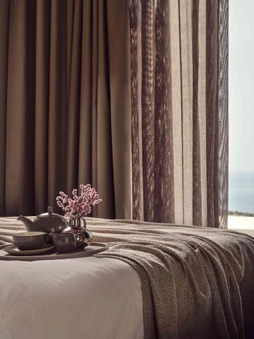 Elegantes Hotelzimmer mit Blick auf das Meer durch bodentiefe Fenster