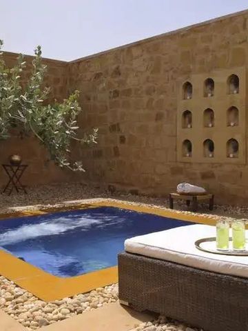 Privater Garten mit Pool und Liegen im Wüstenresort