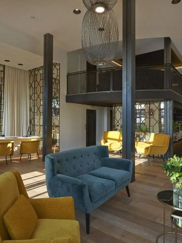 Moderne Lounge mit stilvollen Sesseln, Holzboden und großen Fenstern im Hotel Serras Barcelona