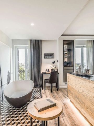 Schickes Zimmer mit freistehender Wanne, großem Fenster und stilvollem Interieur im Hotel Serras