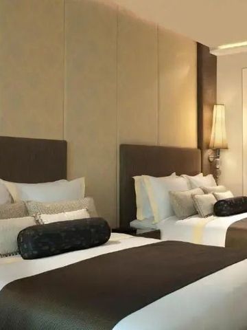 Zimmer mit zwei luxuriösen Betten und stimmungsvoller Beleuchtung.