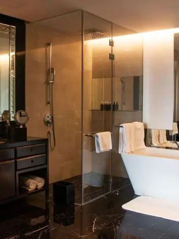 Exklusives Hotelbad mit freistehender Badewanne und beleuchtetem Spiegel