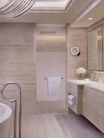 Luxuriöses Hotelbad mit freistehender Badewanne und eleganten Marmoroberflächen