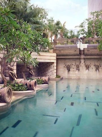 Harmonischer Außenpool mit dekorativen Wasserspielen und tropischer Bepflanzung