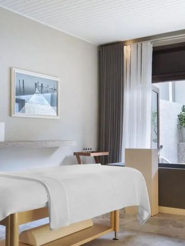 Moderner Spa-Raum mit großem Fenster und Massagebereich