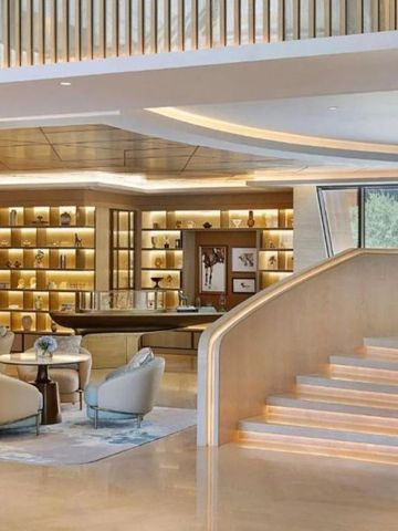 Moderne Hotel-Lounge mit eleganter Treppe und Designer-Möbeln