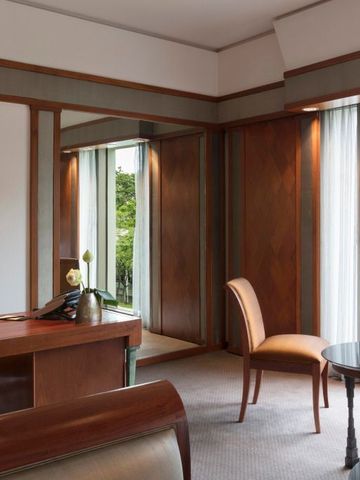 Luxuriöses Hotelzimmer mit Holzmöbeln und Blick auf den Garten