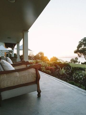 Veranda mit Meerblick und komfortablen Sesseln bei Sonnenuntergang