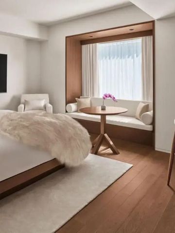 Stilvolles Hotelzimmer mit großem Bett und Sitzbereich am Fenster
